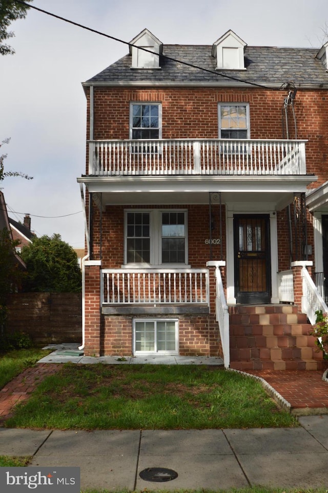 view of front of house with a porch, a balcony, and brick siding