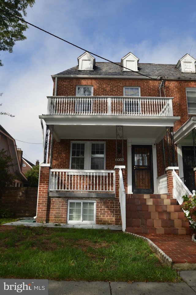 view of front of property with a porch, a balcony, and brick siding