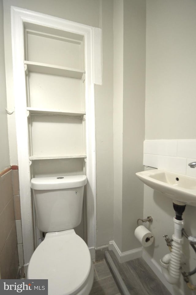 bathroom with toilet and wood finished floors