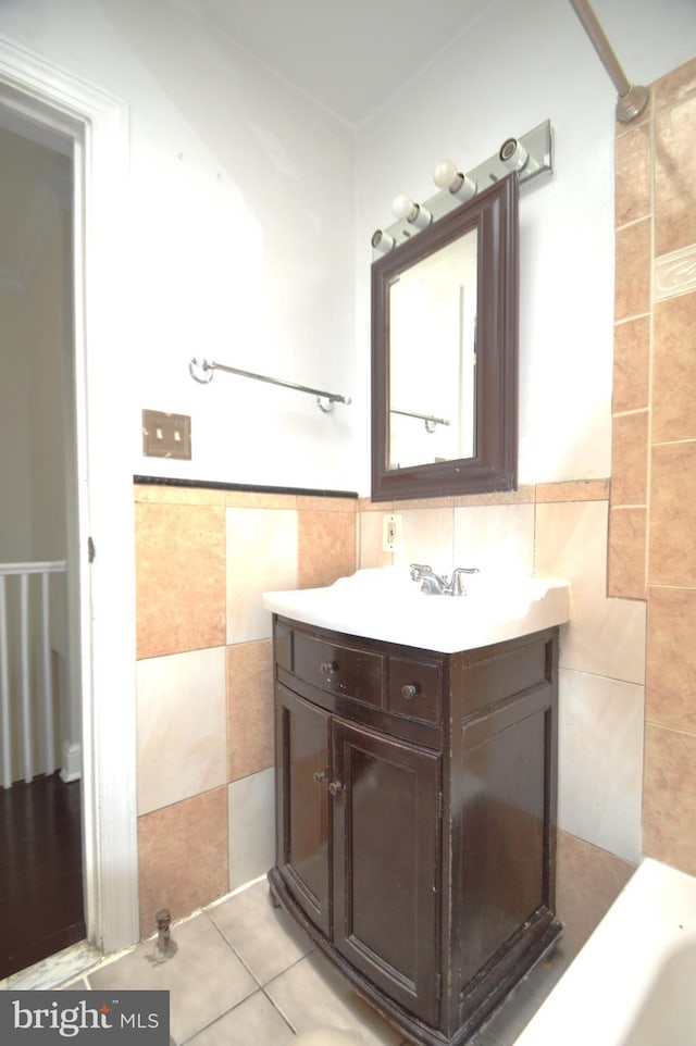 bathroom featuring tile patterned floors, wainscoting, tile walls, and vanity