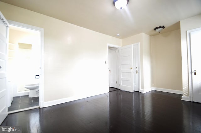 empty room featuring baseboards and wood finished floors