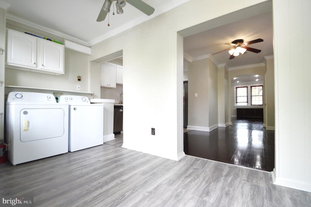 laundry room featuring wood finished floors, washing machine and clothes dryer, cabinet space, ceiling fan, and ornamental molding