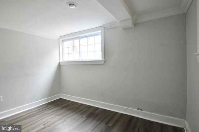 spare room featuring baseboards, dark wood-style flooring, and crown molding