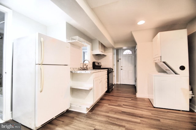 kitchen featuring white cabinets, range with gas cooktop, freestanding refrigerator, and wood finished floors