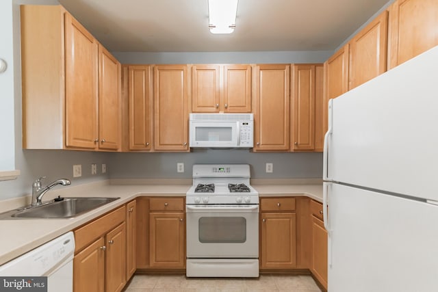 kitchen featuring light brown cabinets, light countertops, light tile patterned floors, white appliances, and a sink