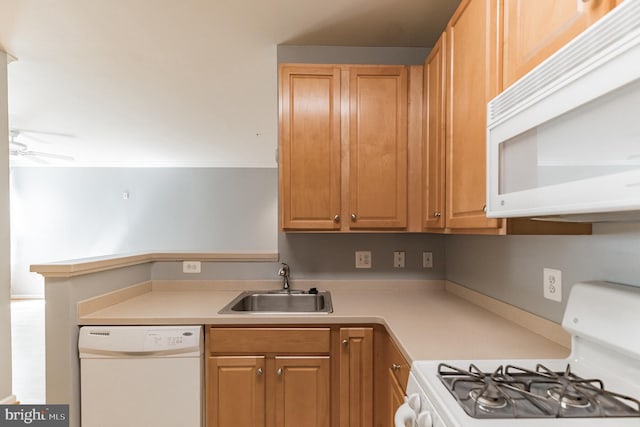 kitchen with light countertops, a peninsula, white appliances, a ceiling fan, and a sink