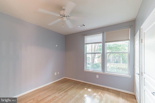 unfurnished room featuring visible vents, light wood-style flooring, baseboards, and ceiling fan