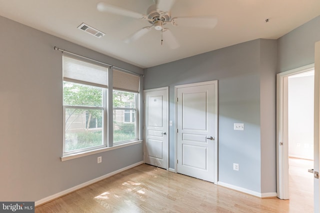 unfurnished bedroom featuring visible vents, baseboards, light wood-style floors, and ceiling fan