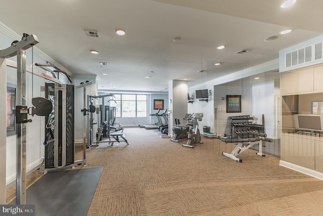 workout area featuring light carpet, visible vents, and ornamental molding