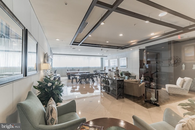 living area featuring a tray ceiling and light tile patterned flooring