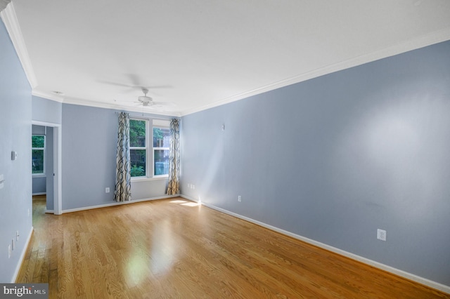 empty room with ceiling fan, baseboards, wood finished floors, and ornamental molding