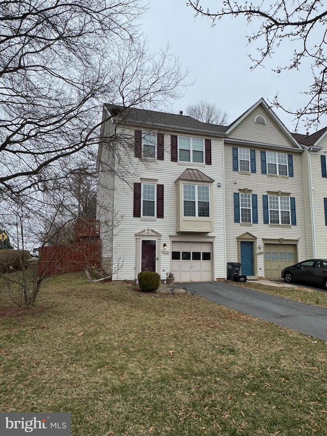 view of front facade featuring aphalt driveway, a garage, and a front lawn