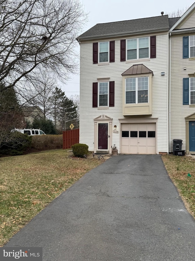 view of front of home featuring a garage, fence, a front lawn, and aphalt driveway