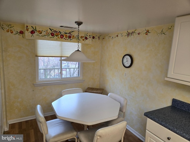 dining room featuring dark wood finished floors, visible vents, and baseboards