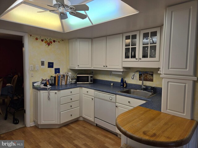 kitchen with a ceiling fan, white dishwasher, a sink, white cabinets, and stainless steel microwave