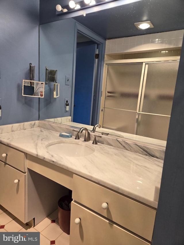 full bathroom with tile patterned flooring, a stall shower, and vanity