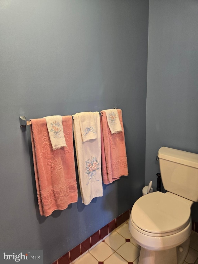 bathroom with tile patterned floors, toilet, and baseboards