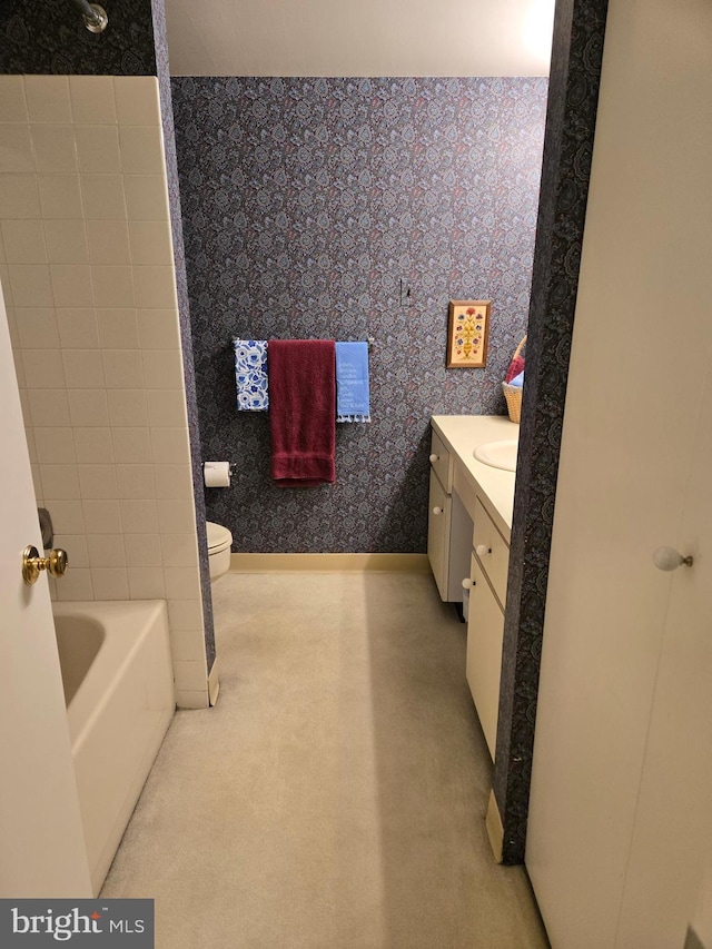 full bath featuring toilet, wallpapered walls, and vanity