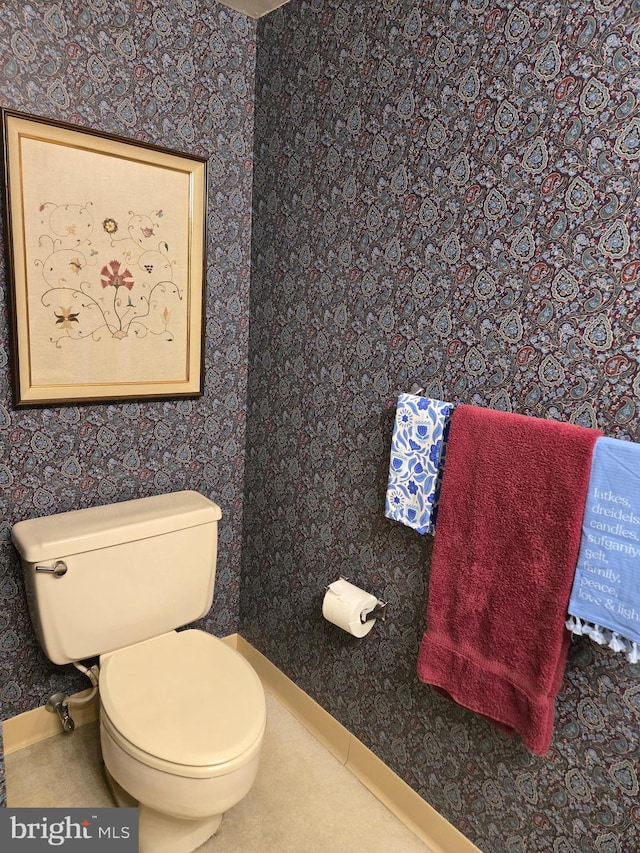 bathroom featuring wallpapered walls, toilet, and baseboards