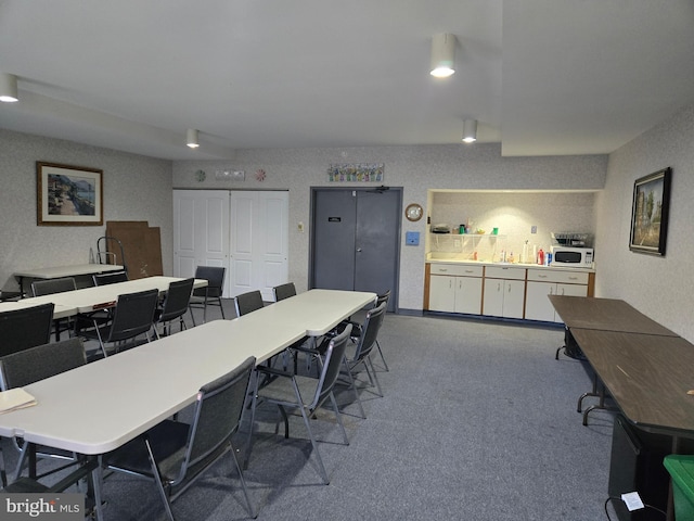 carpeted office space featuring a sink