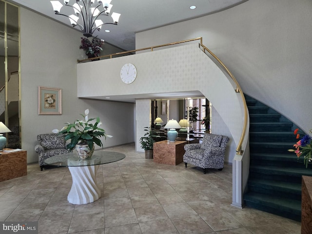 interior space with tile patterned floors, a high ceiling, an inviting chandelier, and stairs