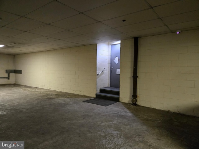 finished basement with a drop ceiling and concrete block wall