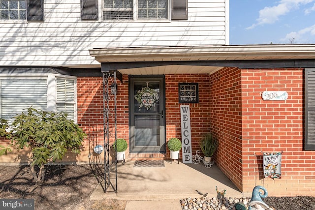 view of exterior entry with brick siding