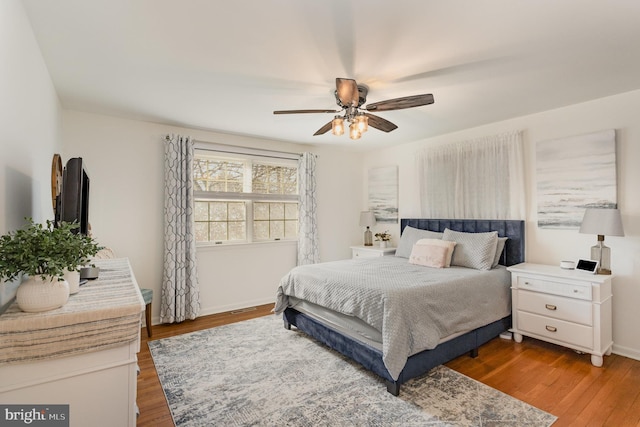 bedroom with baseboards, wood finished floors, and a ceiling fan