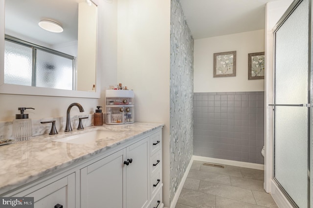 full bath with tile walls, a stall shower, vanity, and tile patterned flooring