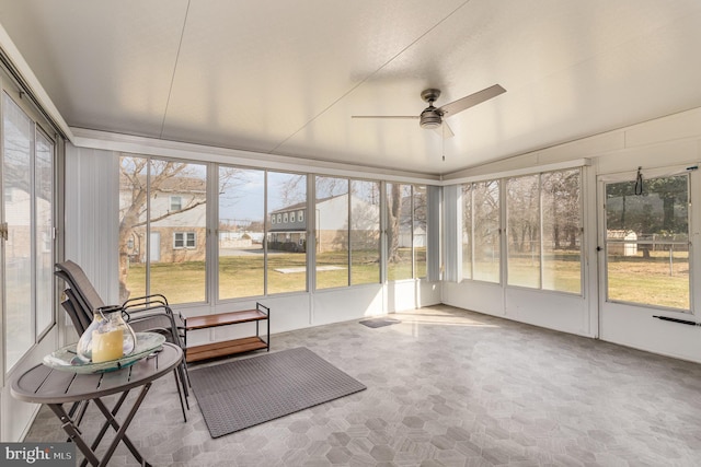 unfurnished sunroom with ceiling fan