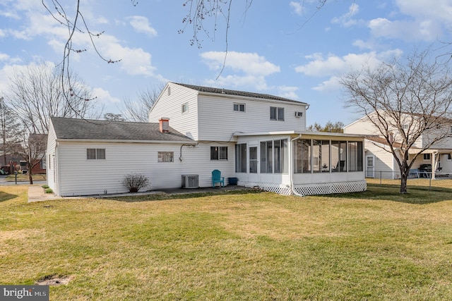 rear view of property with central air condition unit, fence, a yard, and a sunroom