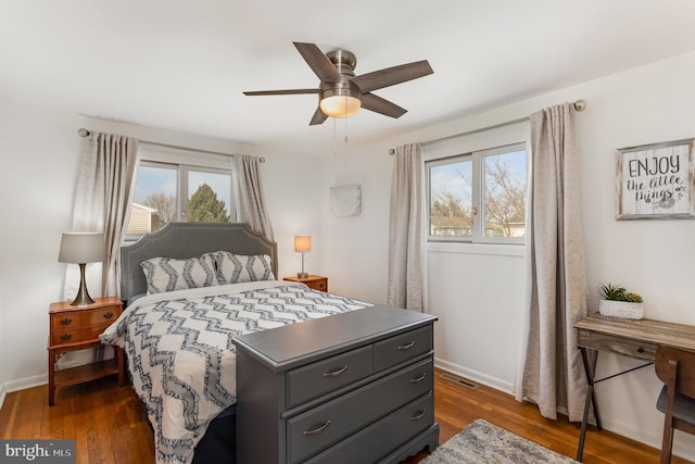 bedroom featuring dark wood finished floors, multiple windows, and baseboards