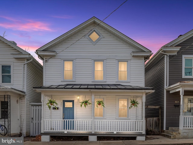 view of front of house featuring a porch, metal roof, and a standing seam roof