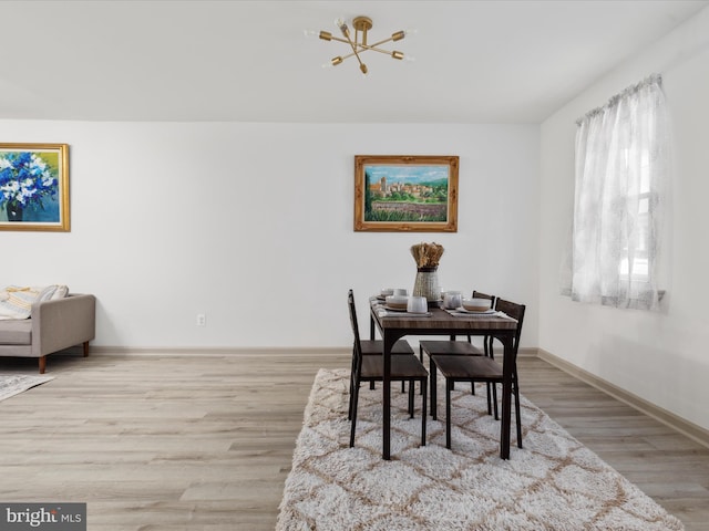 dining area with an inviting chandelier, wood finished floors, and baseboards