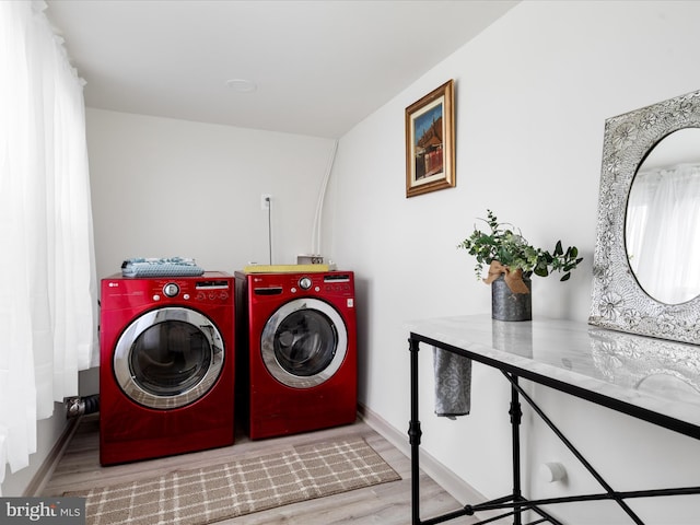 laundry room with baseboards, washing machine and dryer, wood finished floors, and laundry area