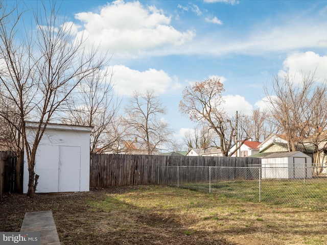 view of yard featuring an outbuilding, a storage shed, and a fenced backyard