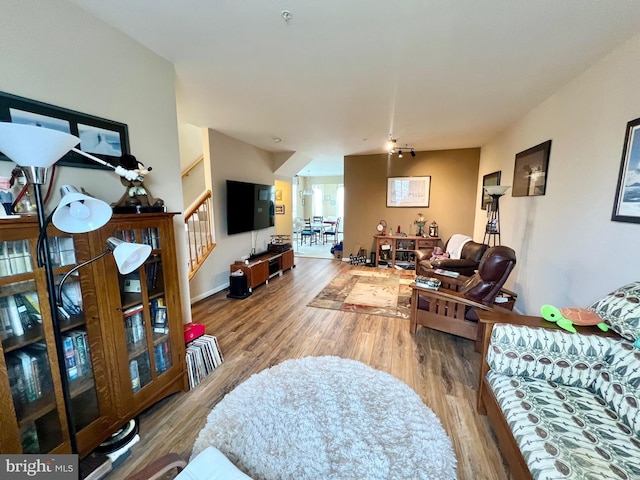 living room with stairs and wood finished floors