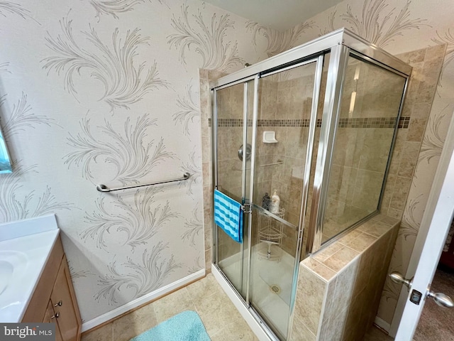 bathroom with wallpapered walls, vanity, a stall shower, and baseboards