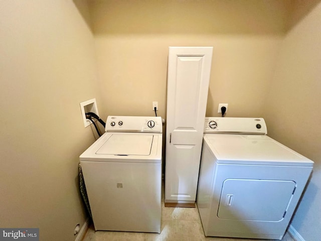 clothes washing area featuring washer and dryer, baseboards, and laundry area