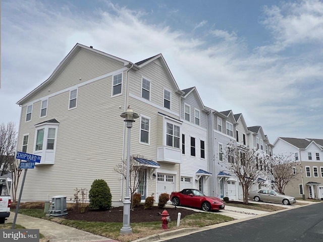 exterior space with central air condition unit, a residential view, and an attached garage