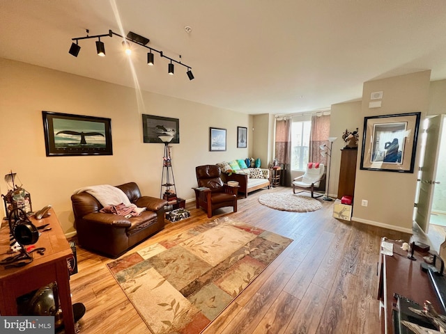 living room with rail lighting, baseboards, and wood finished floors