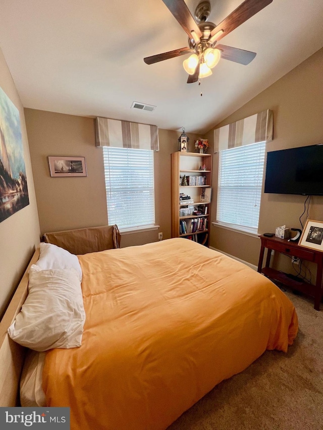 carpeted bedroom featuring vaulted ceiling, visible vents, and ceiling fan