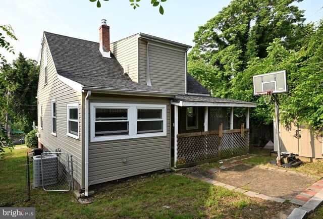 3910 Billings Pl, Capitol Heights, MD 20743 - back of house featuring central air condition unit, a chimney, roof with shingles, an outbuilding, and fence