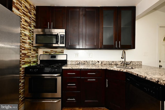 3910 Billings Pl, Capitol Heights, MD 20743 - kitchen with appliances with stainless steel finishes, a sink, light stone counters, glass insert cabinets, and dark brown cabinetry