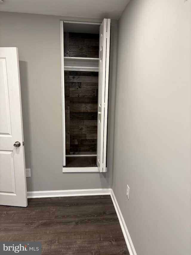 empty room featuring wood finished floors and baseboards