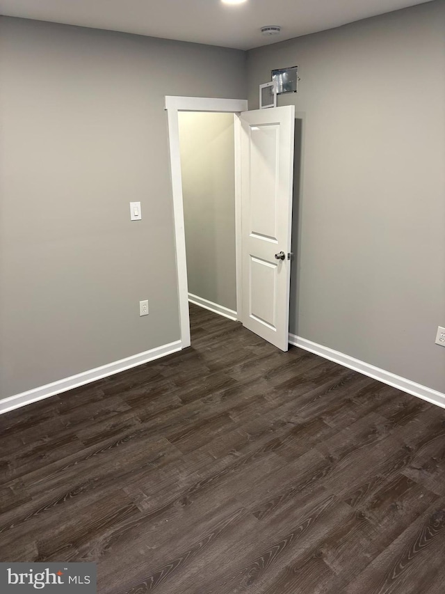 unfurnished room featuring dark wood finished floors and baseboards