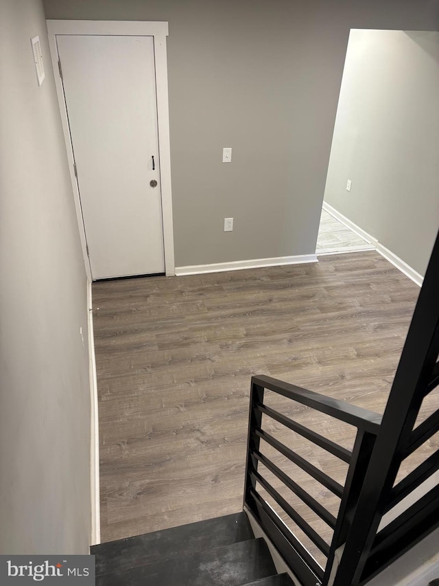 stairway with wood finished floors and baseboards