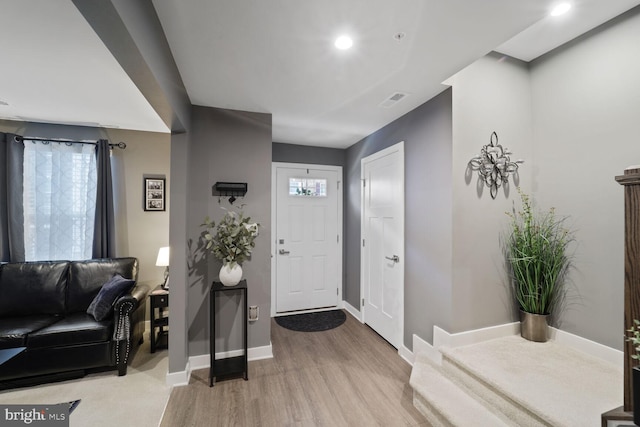 foyer with visible vents, baseboards, plenty of natural light, and wood finished floors