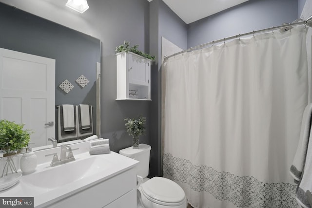 full bathroom with vanity, a shower with shower curtain, and toilet