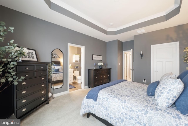 bedroom featuring visible vents, baseboards, light colored carpet, ensuite bath, and a raised ceiling